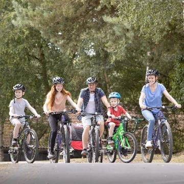 Family riding bicycles through Parkdean Resorts