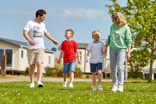 Family walking hand in hand smiling