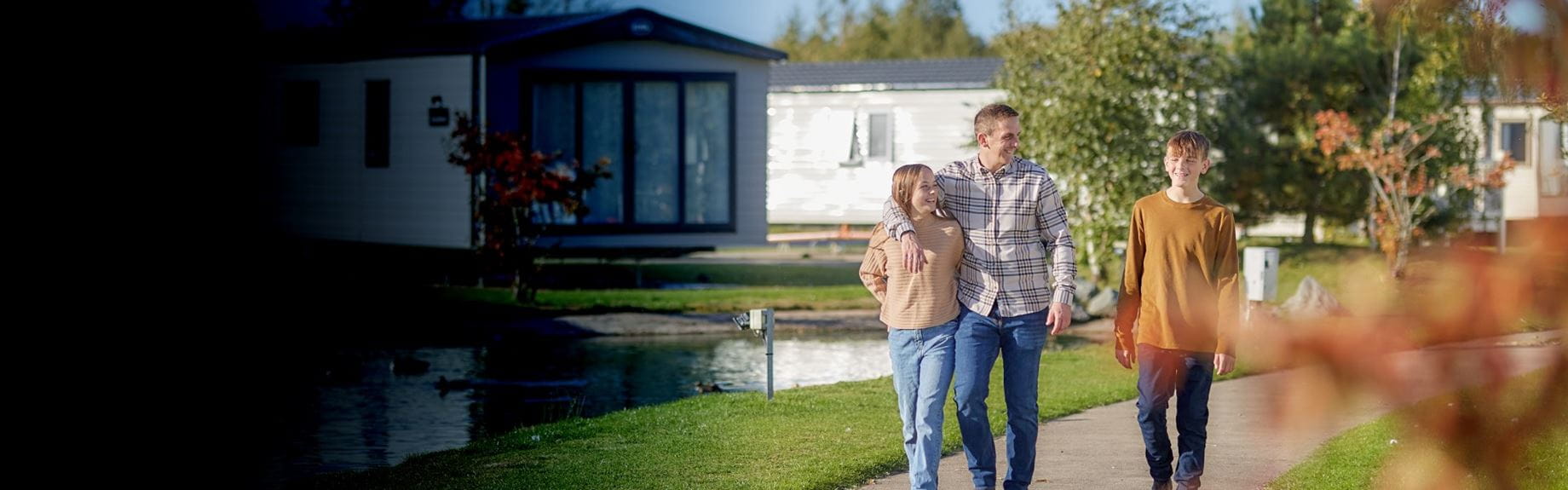 Family walking by lakeside caravans