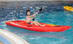A child kayaking at an indoor swimming pool