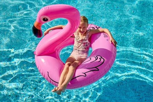 Girl on pink inflatable flamingo