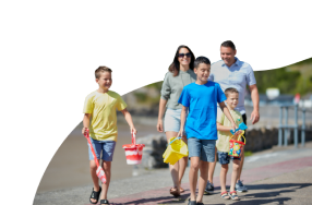 Family walking together with bucket and spades