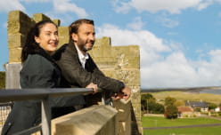 A couple looking out from a castle wall