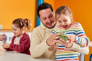 Dad and daughter playing with green slime