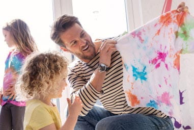 Dad and daughter looking at tie dye creation
