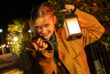 Child in Halloween fancy dress holding lantern