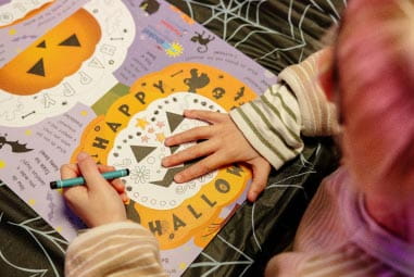 Child drawing on pumpkin