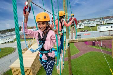 Girl climbing the high ropes at Parkdean Resorts