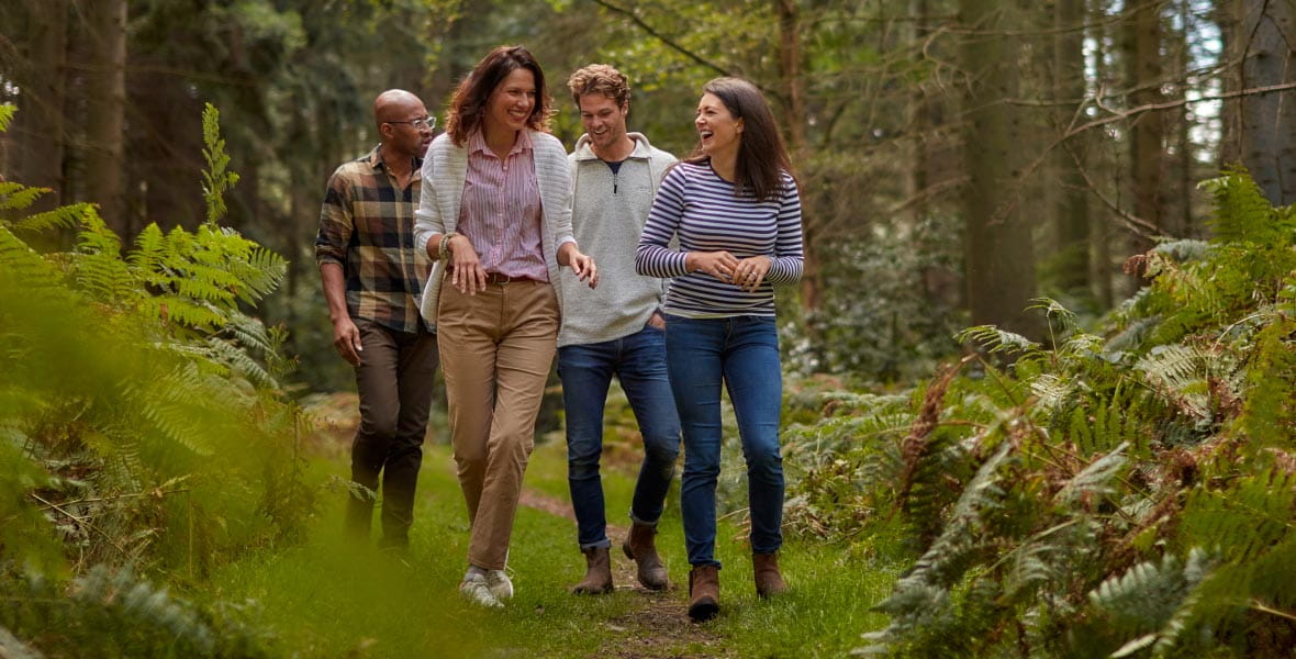 Two men and two women looking happy in a forest