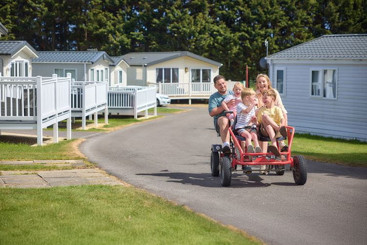 Family on kart by caravans