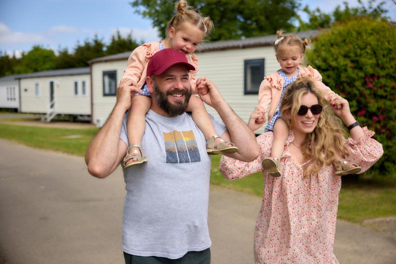 Family walking with children on shoulders