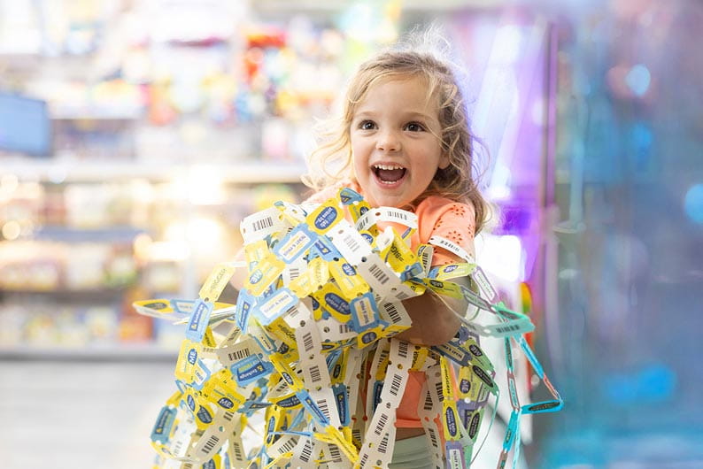 Little girl holding arcade tickets