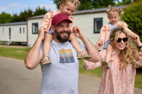Family walking with children on shoulders