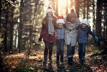 Children walking arm in arm wrapped up in winter coats and wooly hats