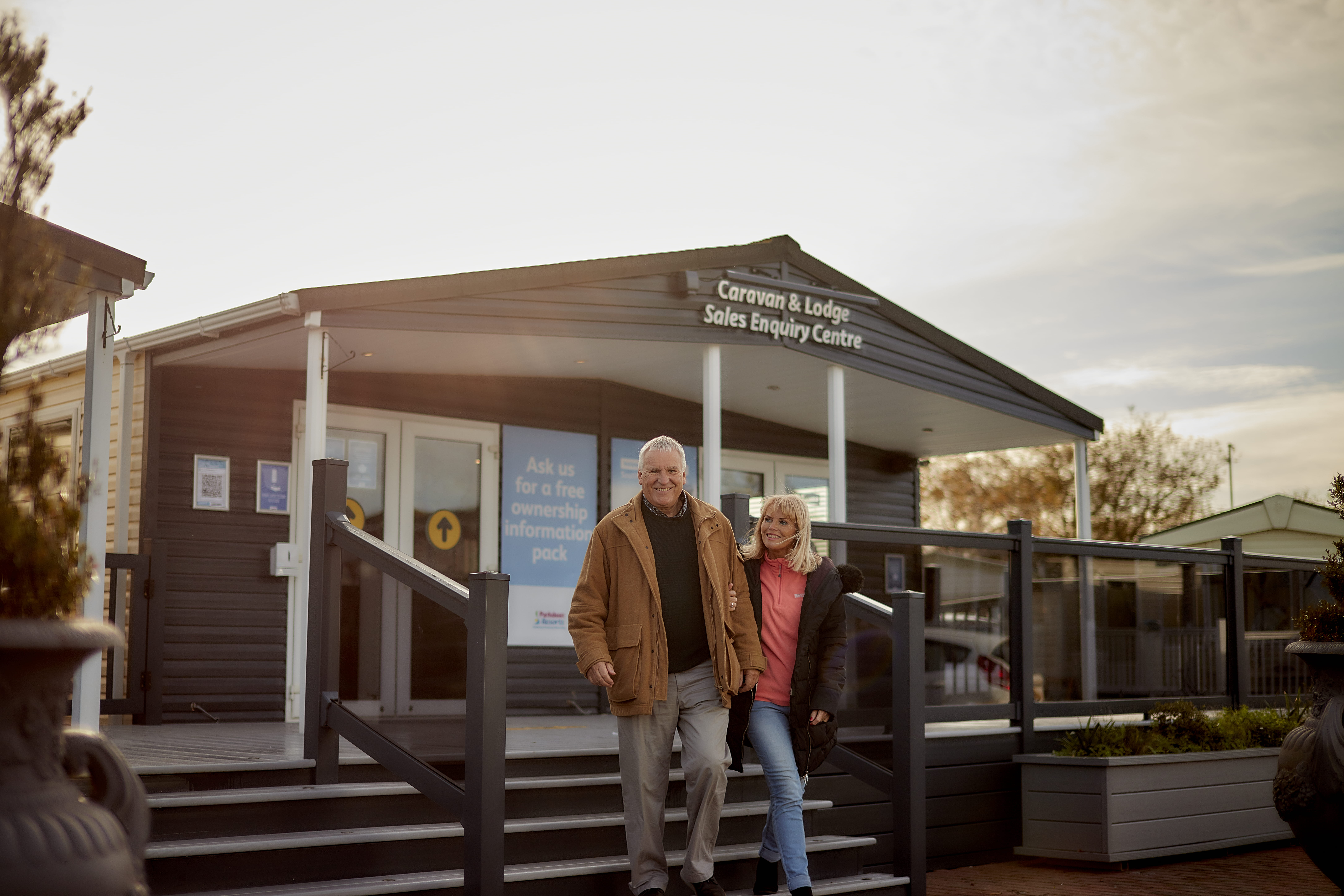Man and woman walking out of reception of Parkdean Resorts hand in hand