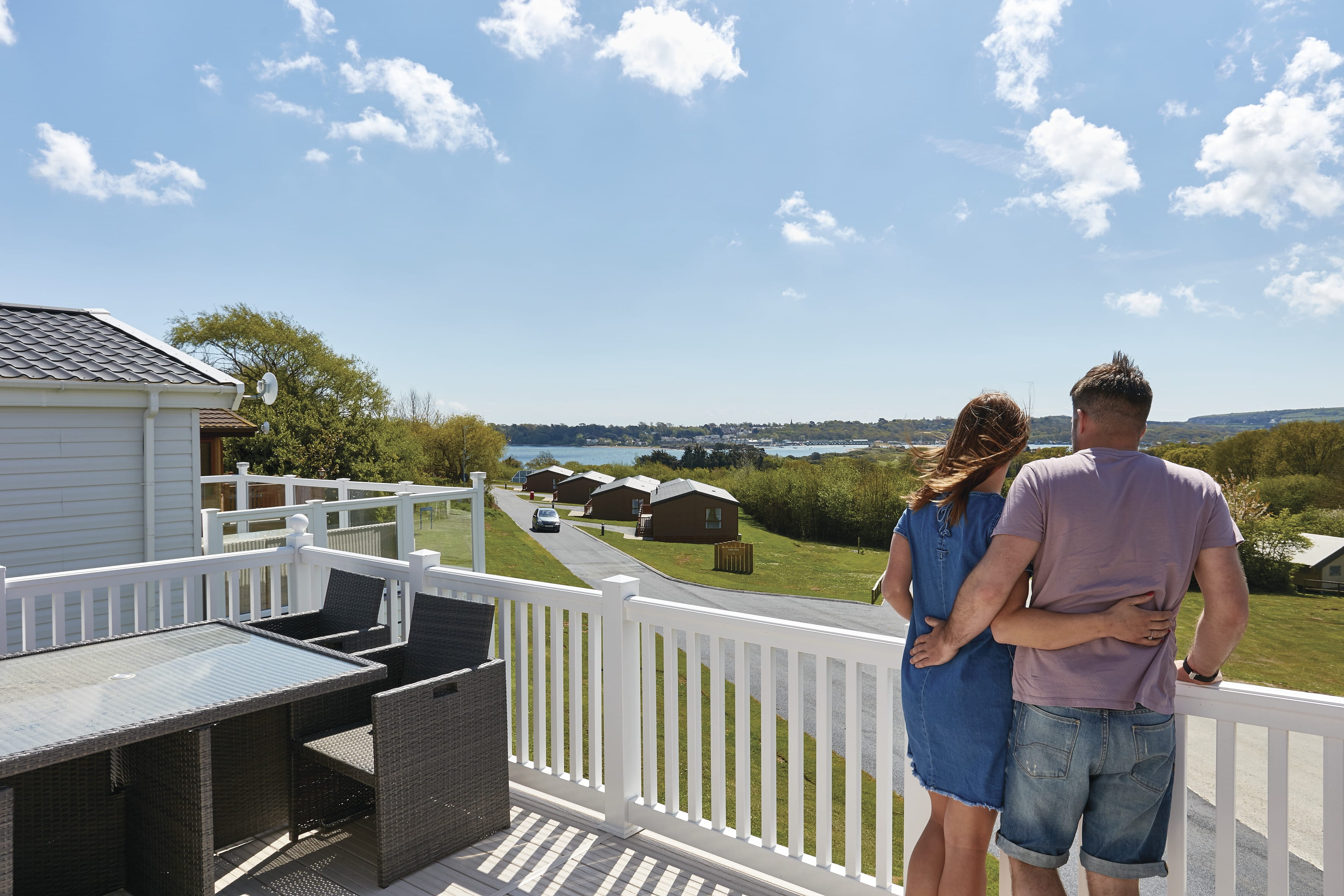 Man and woman standing on caravan veranda looking out at Parkdean Resorts