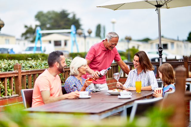 Family sat around a table eating and drinking