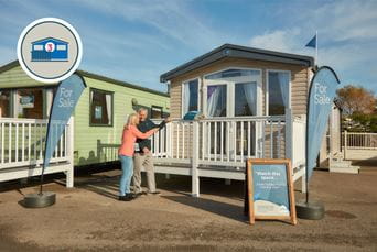 A couple viewing a static caravan for sale on a showground at Parkdean Resorts