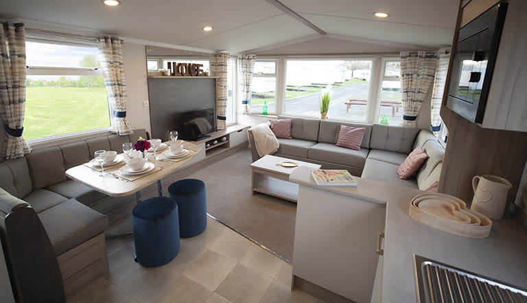 The spacious dining area and living room of a Swift Loire caravan