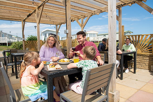 A family enjoying food under the outdoor canopy at Barmston Beach