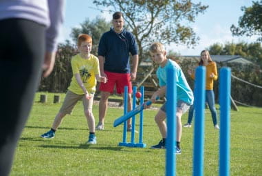 a family playing cricket outside