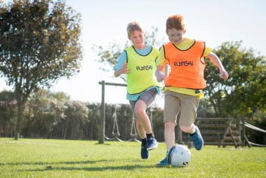 two boys playing football outside