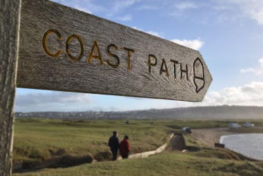 a couple walking along a coastal path