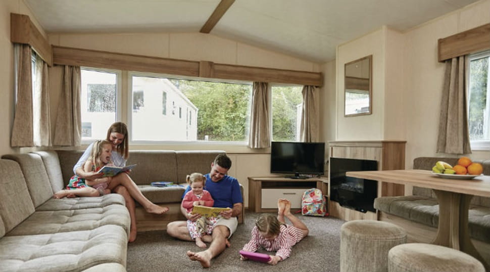 family relaxing in the lounge area of a luxury caravan