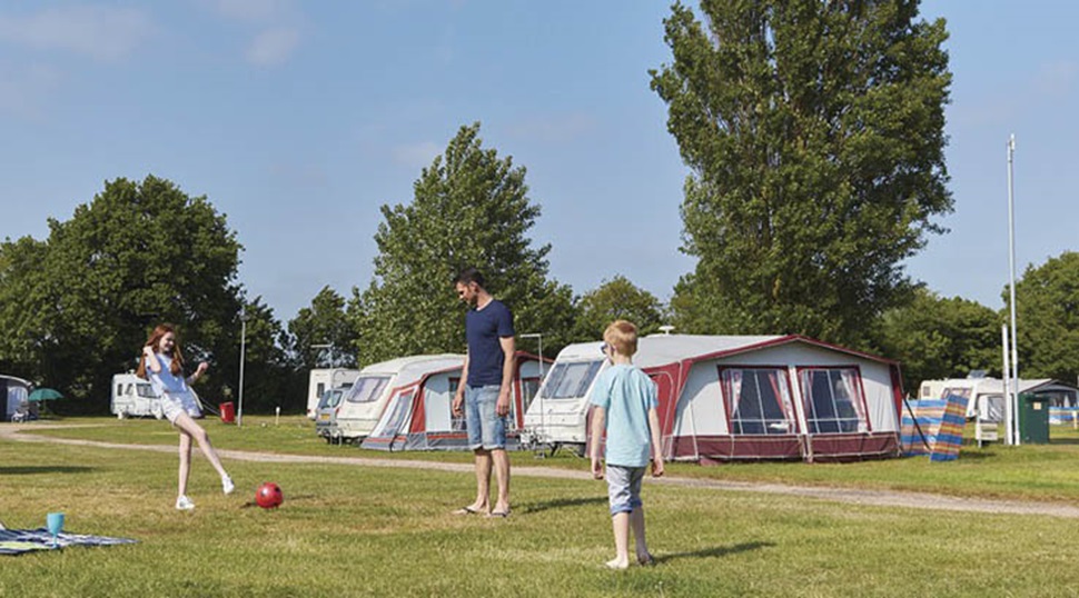 family playing ball games on a camping field