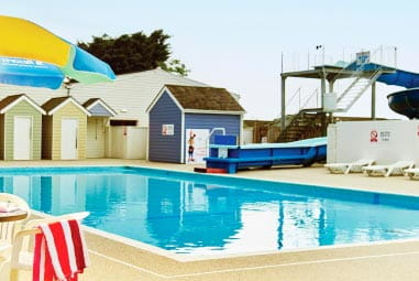 a water slide heading into an outdoor pool