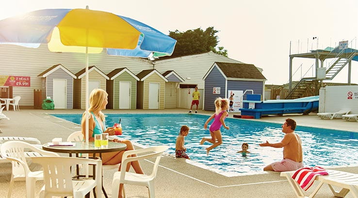 people enjoying the outdoor swimming pool on a sunny day