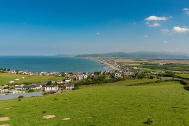Vast view of a seaside town with fields and the coast in the background