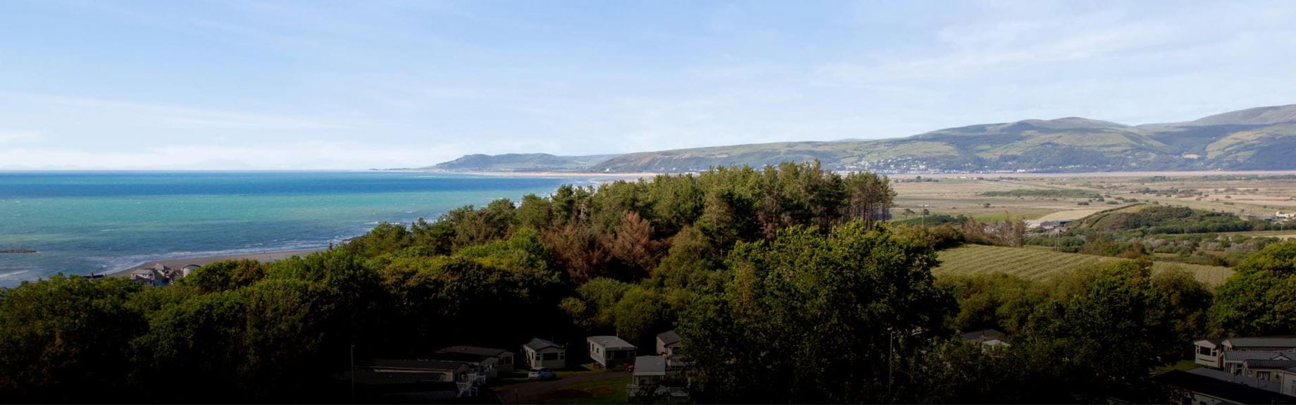 Picturesque view of a countryside with rolling hills next to a blue sea