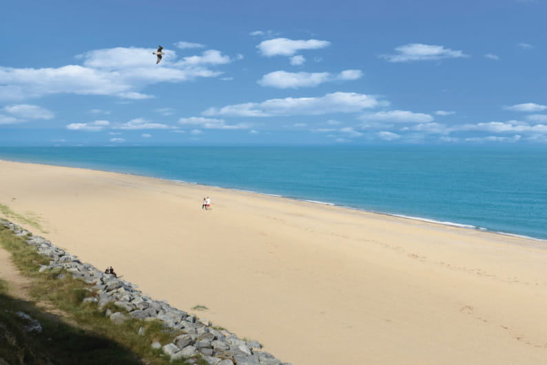 Sandy beach, blue sea and sky