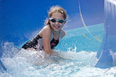 Child descending a waterslide in goggles