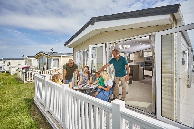 A family socialising on the caravan veranda at Camber Sands Holiday Park