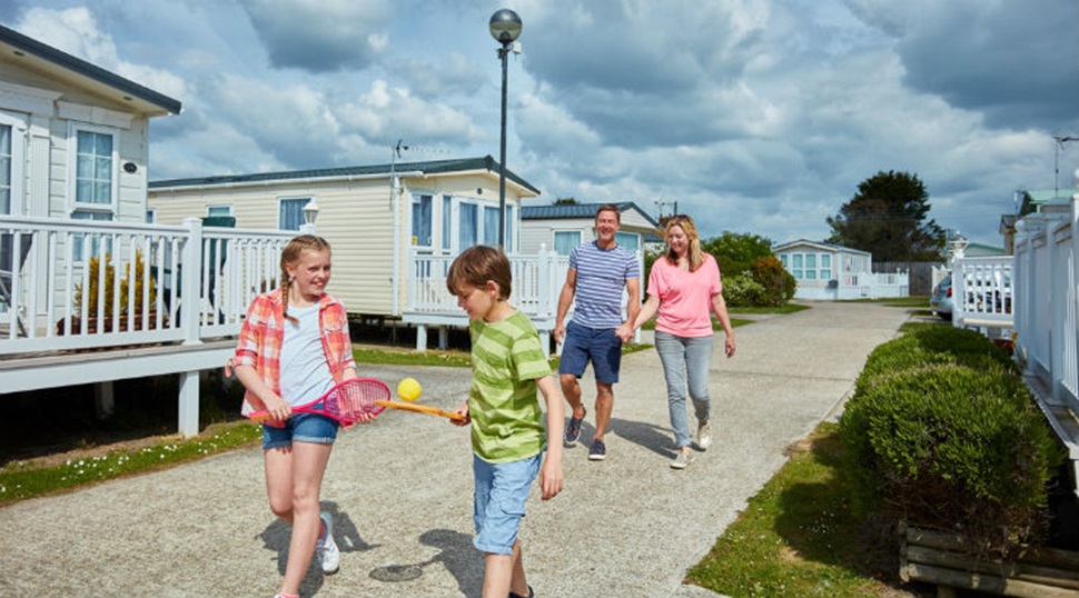 A family strolling through Camber Sands Holiday Park on a sunny day