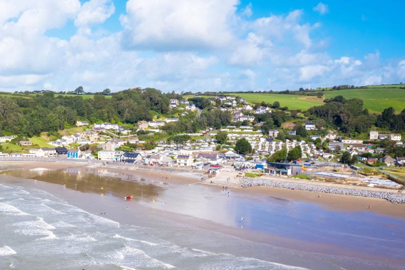 a holiday park with a beach and blue sea in the foreground
