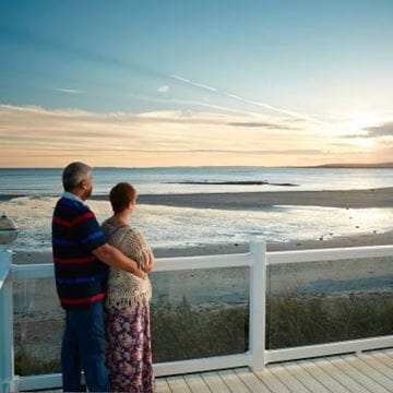 a couple looking out at the sea at sun set