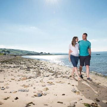 a couple strolling along the beach