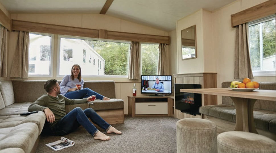 A couple relaxing and watching TV in their caravan living room
