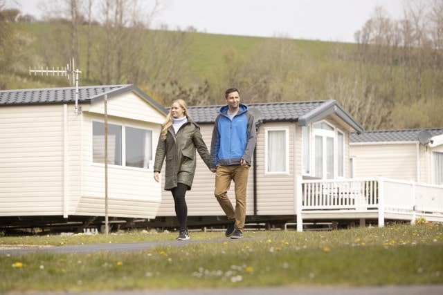 Couple walking outside Challaborough Bay park home