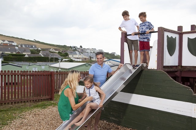 A family enjoying the outdoor adventure play area at Challaborough Bay Holiday Park
