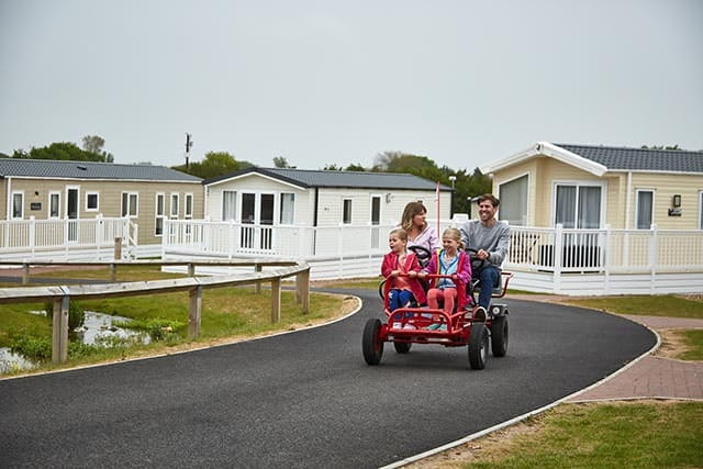 Family ride kart outside park homes at Cherry Tree Holiday Park