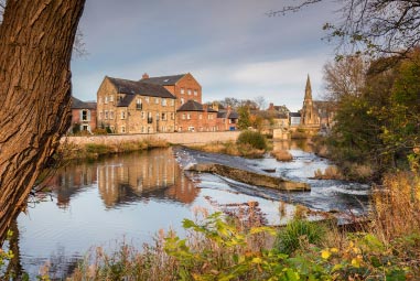 Historic leafy village by a river