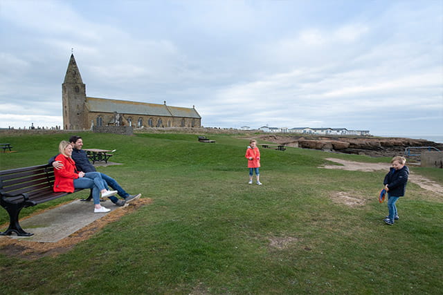 A family sat on a bench at Church Point Holiday Park