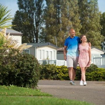 Man walking with arm around woman's shoulders