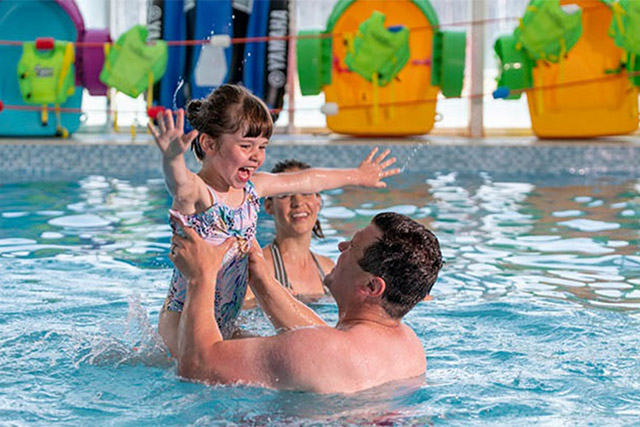 A family splashing in the indoor swimming pool