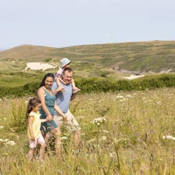 A family walking through a green field