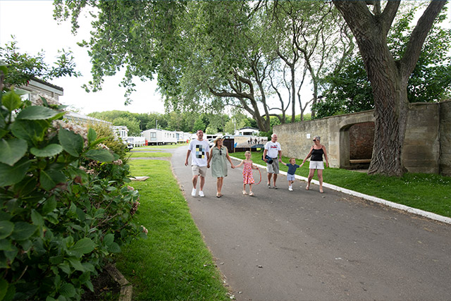 A family walking through Cresswell Towers Holiday Park